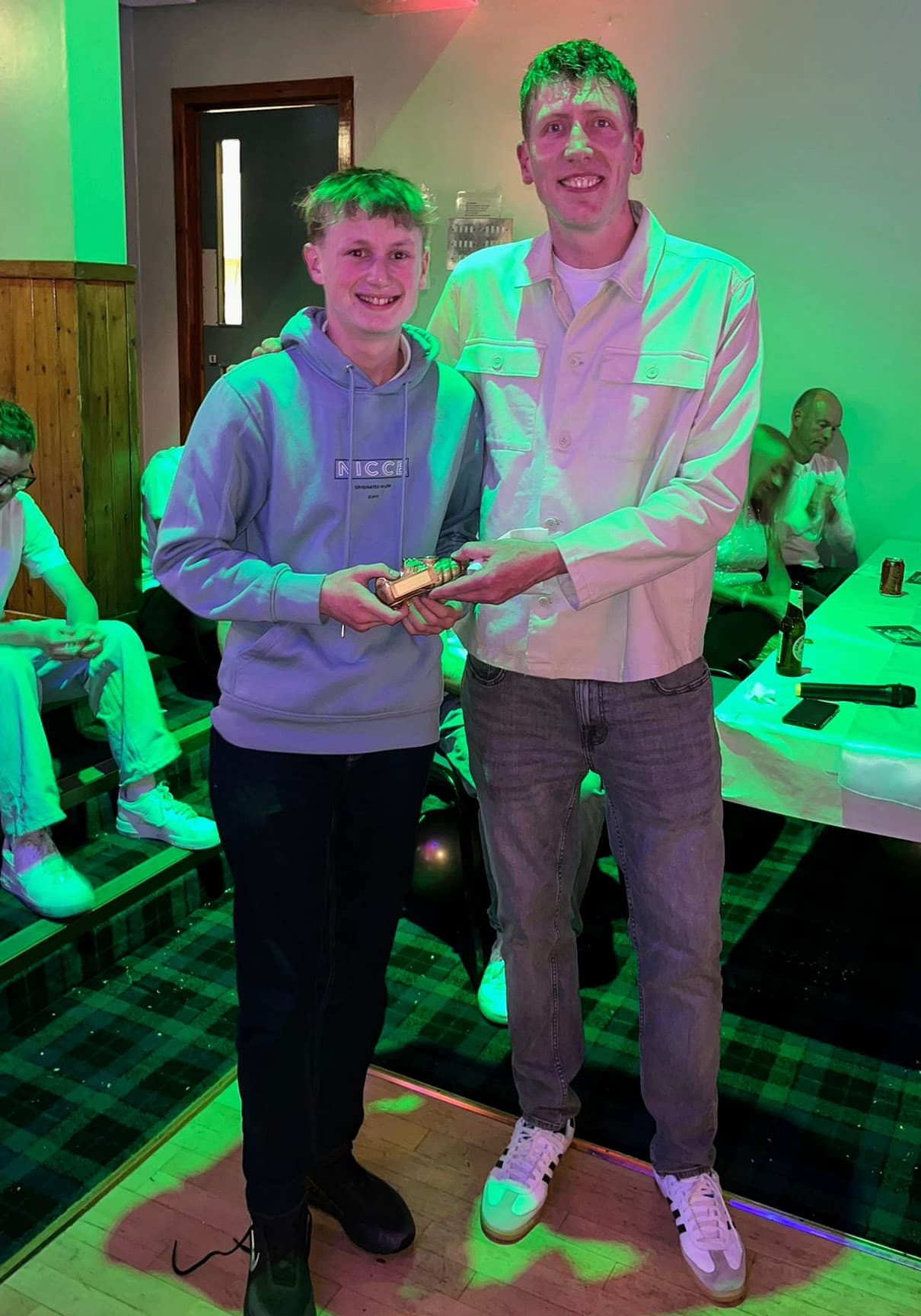 A young award recipient receiving a golden boot trophy