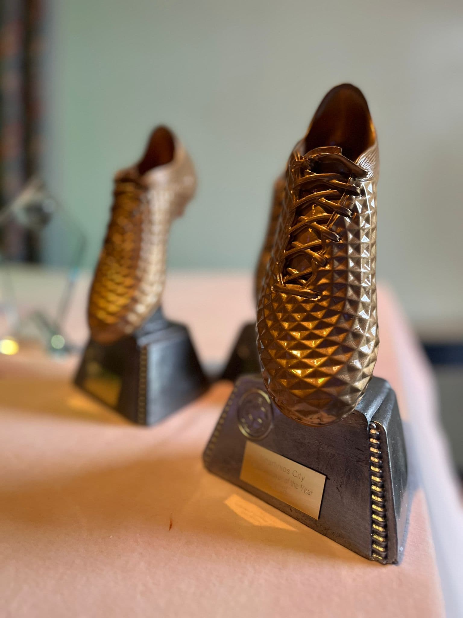 Close-up of golden boot trophies on the awards table