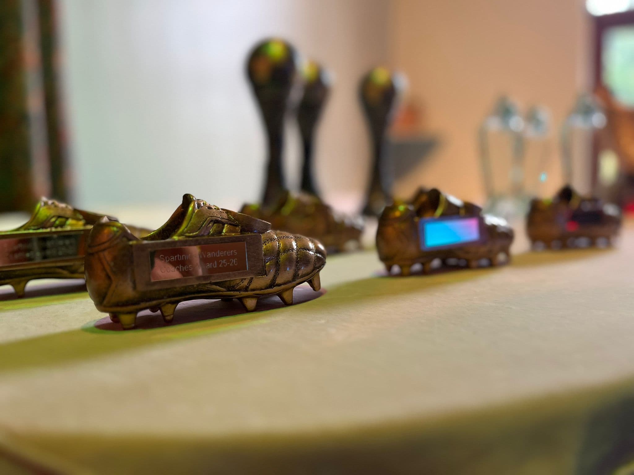 Golden boot trophies lined up on the awards table