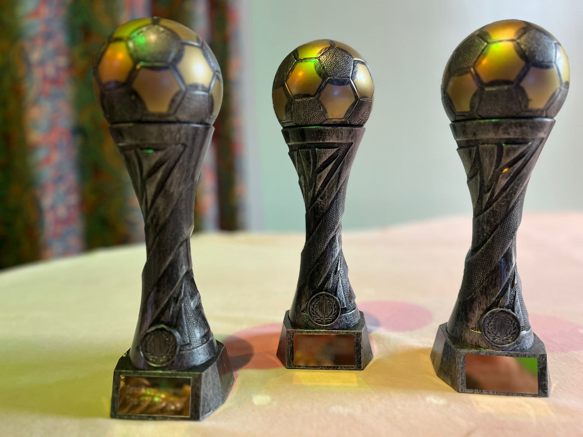 Three football trophies displayed together at the awards night