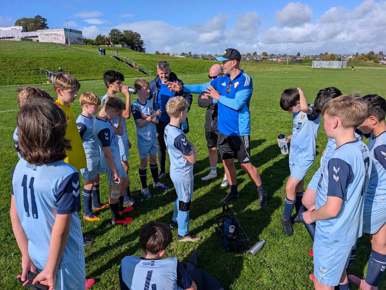 Wanderers players listening to their coaches on the pitch