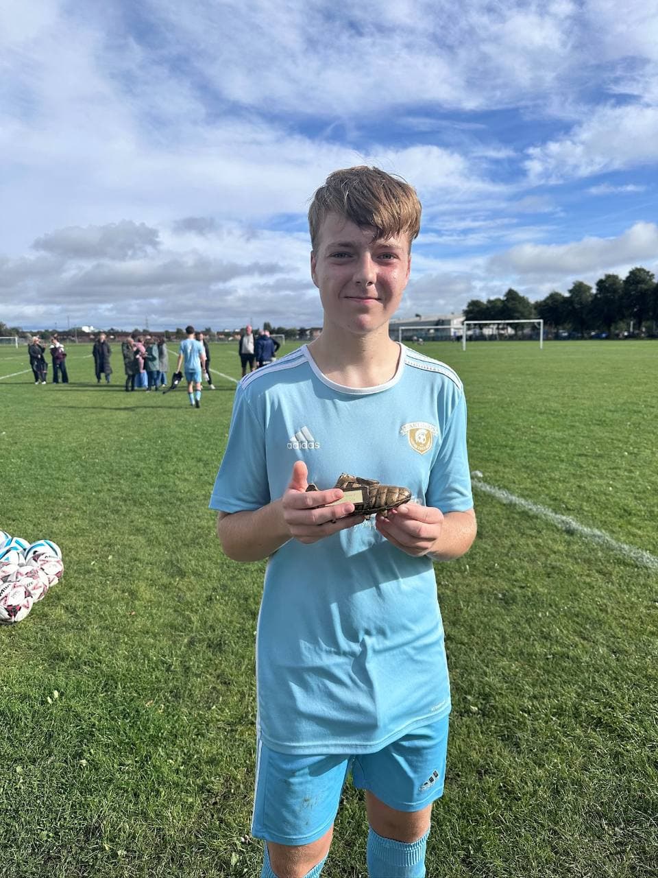 City Coaches’ Award winner holding his award on the pitch